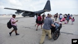 U.S. Air force personnel evacuate residents from Princes Juliana International Airport after the passage of Hurricane Irma, in St. Martin, Sept. 12, 2017. Irma cut a path of devastation across the northern Caribbean, leaving thousands homeless after destroying buildings and uprooting trees. 