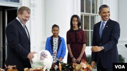 Presiden Barack Obama (kanan) mengampuni Kalkun Thanksgiving 'Liberty', disebelah Sasha, putrinya (kedua dari kiri) dan Malia di Gedung Putih (23/11)