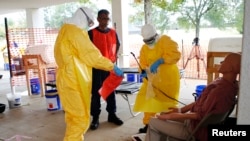 Centers for Disease Control and Prevention instructor Satish Pillai (C) gives guidance to Paul Reed (L), chief medical officer for the U.S. Public Health Service, and Roseda Marshall, chairman of pediatrics at the University of Liberia's A.M. Dogliotti Co