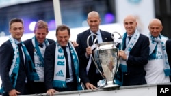 Zinedine Zidane et ses assistants tenant le trophée de la ligue des champions, Madrid le 27 mai 2018.
