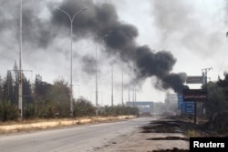 Smoke rises near a damaged road in Dahiyet al-Assad, west Aleppo city, Syria, Oct. 30, 2016.