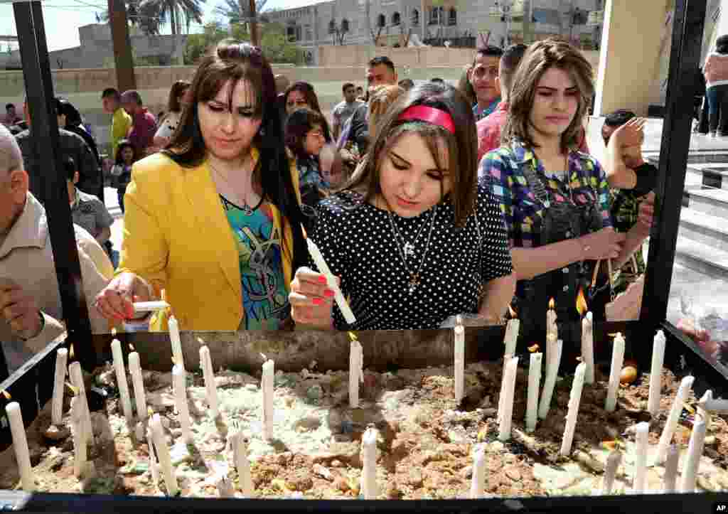 Iraqis women light candles after the Palm Sunday service at Lady Deliverance Church in Baghdad, April 5, 2015.
