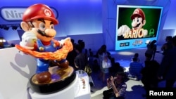 Para pengunjung berfoto dekat karakter Mario, yang tampil dalam game 'Super Smash Bros," dalam pameran hiburan elektronik di Los Angeles, California, 11 Juni 2014. (Foto:dok)