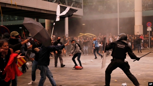 Policías antidisturbios se enfrentan con manifestantes afuera del aeropuerto El Prat de Barcelona, España, el 14 de octubre de 2019.