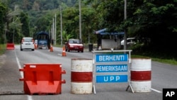A check point is seen at the entry point to Malaysia - Thailand border in Wang Kelian, Malaysia on Sunday, May 24, 2015. Malaysian authorities said Sunday that they have discovered graves in more than a dozen abandoned camps used by human traffickers. 