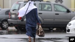 یک مرد در لباس سنی در دبی راه می رود.
