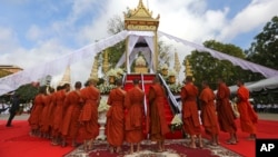 Buddhist monks chant around a cremation site for the body of Ouk Phalla, Prince Norodom Ranariddh's wife, during the cremation ceremony, in Phnom Penh, Cambodia, Wednesday, June 20, 2018. The Cambodian prince who is a candidate in upcoming elections was transferred to a hospital in neighboring Thailand on Monday, June 18, after being injured in a road crash that killed his wife, a fellow politician said. (AP Photo/Heng Sinith)