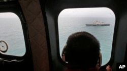 Un barco militar es visto dede un avión de la Fuerza Aérea indonesia durante las operaciones de búsqueda del avión de AirAsia, las cuales se han ampliado. 