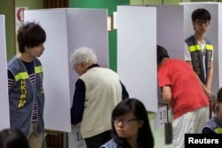 People vote at a polling station during Occupy Central's unofficial referendum on democratic reforms in Hong Kong June 29, 2014.