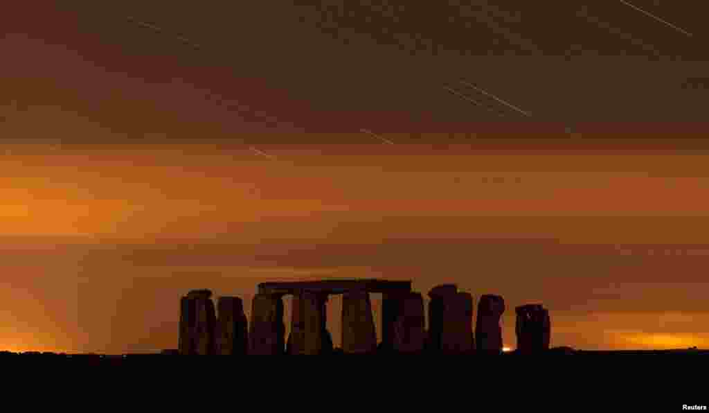 Quang cảnh Stonehenge giữa bầu trời đêm trong trận mưa sao băng Perseid hàng năm ở Salisbury Plain, miền nam nước Anh. Trận mưa sao băng Perseid diễn ra mỗi tháng tám khi Trái Đất va quệt dòng mảnh vỡ vũ trụ do sao chổi Swift-Tuttle để lại.