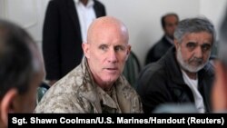 FILE - Vice Adm. Robert Harward, commanding officer of Combined Joint Interagency Task Force 435, speaks to an Afghan official during his visit to Zaranj, Afghanistan, Jan. 6, 2011.