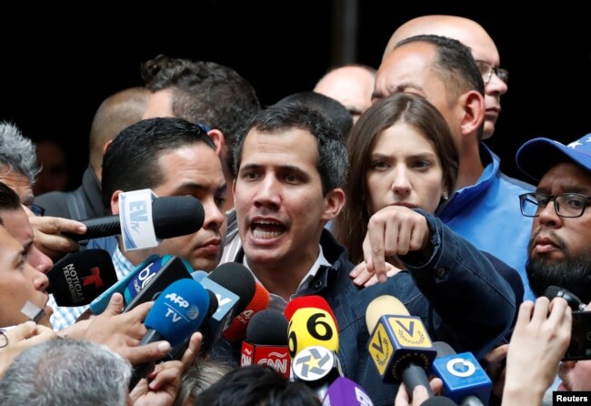 Venezuelan opposition leader and self-proclaimed interim president Juan Guaido, accompanied by his wife Fabiana Rosales, speaks to the media after a church service in Caracas, Venezuela, Jan. 27, 2019.