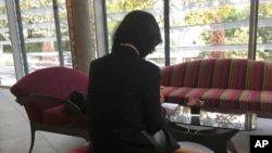 Grace Meng, the wife of missing Interpol President Meng Hongwei, who does not want her face shown, consults her mobile phone in the lobby of a hotel in Lyon, central France, where the police agency is based, on Oct. 7, 2018.