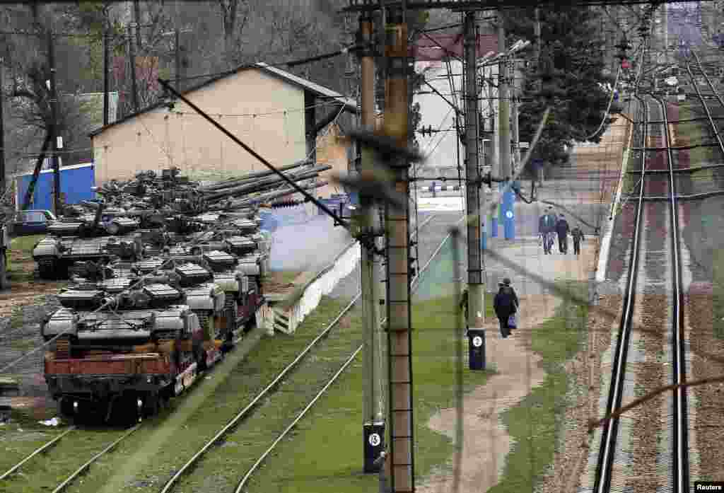 Commuters walk to a train station where Ukrainian tanks are being put onto a train in northern Crimea, March 27, 2014.&nbsp;