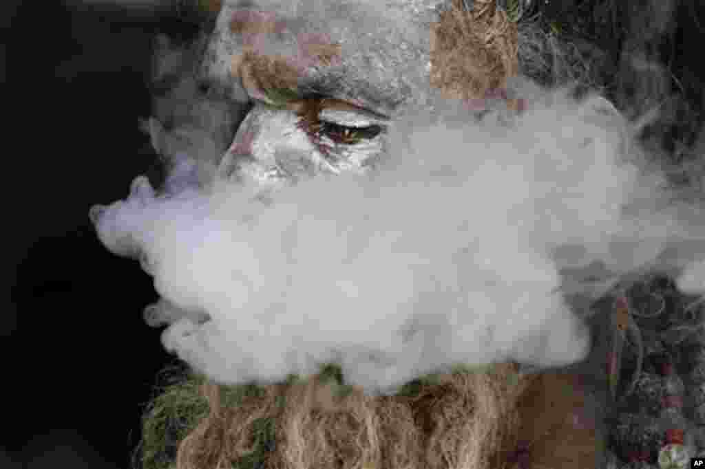 Jan. 5: A sadhu, or Hindu holy man, smokes marijuana at a transit camp in Calcutta, India. (Bikas Das/AP)