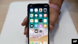 FILE - The iPhone X is displayed in a showroom after the new product announcement at the Steve Jobs Theater on the Apple campus in Cupertino, Calif., Sept. 12, 2017.