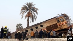 FILE - People gather at the site of a train derailment near Beni Suef, Egypt, Thursday, Feb. 11, 2016 that injured dozens of people were injured as it was traveling north toward Cairo. Railroad accidents due to negligence are common in Egypt.