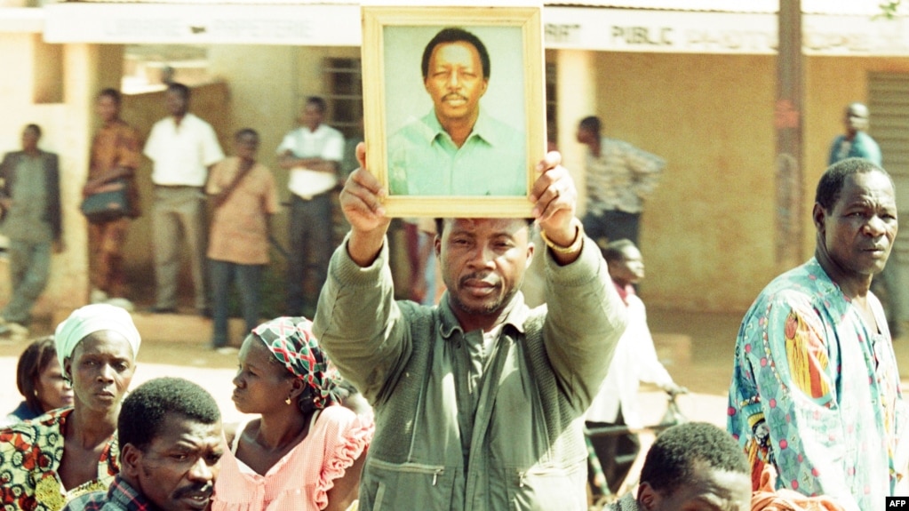 Un homme brandit la photo du journaliste Norbert Zongo lors de ses funérailles à Ouagadougou, Burkina, le 16 décembre 1998.