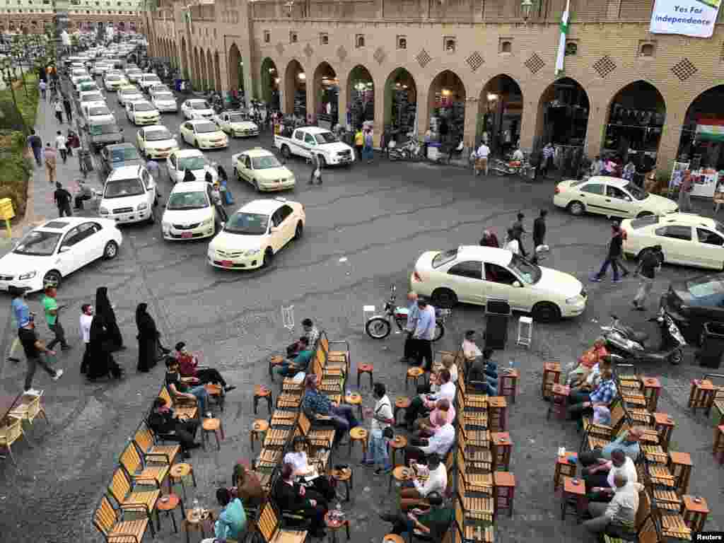 Kurdish people sit at a coffee shop on a street in Irbil, Iraq.