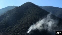 FILE - Smoke rises from a hillside in Dangam district in Afghanistan's eastern Kunar province, Jan. 17, 2015.