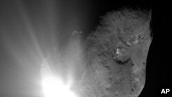 This image provided by NASA shows comet Tempel 1 at the moment of impact with NASA's Deep Impact probe as it smashed into its surface. The probe crashed between the two dark-rimmed craters near the center and bottom of the comet (File Photo - July 4, 2005
