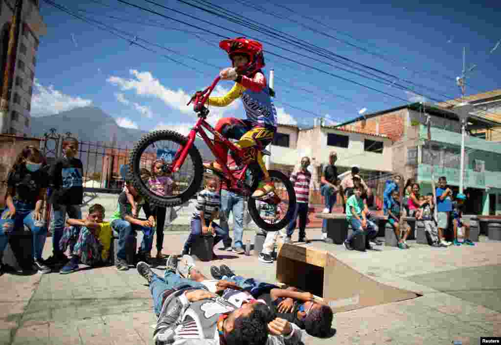 Camila Iachini, 8, performs with her bike during celebrations for the 400th anniversary of the founding of the neighbourhood Petare, in Caracas, Venezuela, Feb. 17, 2021.