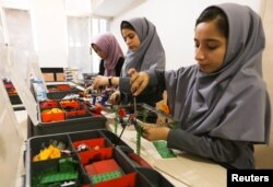 Anggota tim robotika siswi asal Afghanistan yang permohonan visanya untuk masuk AS dalam rangka untuk berkompetisi di bidang robotika ditolak sedang berlatih dengan robot-robotnya di provinsi Herat, Afghanistan, 4 Juli 2017.