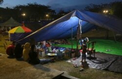 Perempuan mengobrol di dekat tenda di penampungan sementara di Palu, Sulawesi Tengah, 6 Oktober 2018. (Foto: AP)