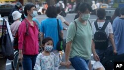 台湾台北街道上的行人戴着口罩预防新冠病毒。（2020年7月28日）