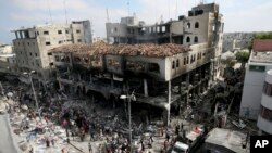 Palestinos observan un edificio tras un ataque israelí en la ciudad de Rafah, Gaza.