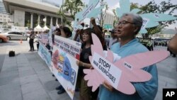 Beberapa aktivis Korea Selatan melakukan unjuk rasa memrotes latihan militer AS-Korsel di dekat Kedutaan AS di Seoul (17/8).