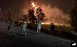 Esta foto provista por la Secretaría de Defensa Nacional muestra a soldados resguardando el área de la explosión de un oleoducto en Tlalhuelilpan, estado de Hidalgo, México, el viernes 18 de 2019.
