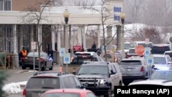 La police dans le parking d'une épicerie où des élèves du lycée d'Oxford ont été placés en attendant leurs parents à Oxford, Michigan, mardi 30 novembre 2021. 