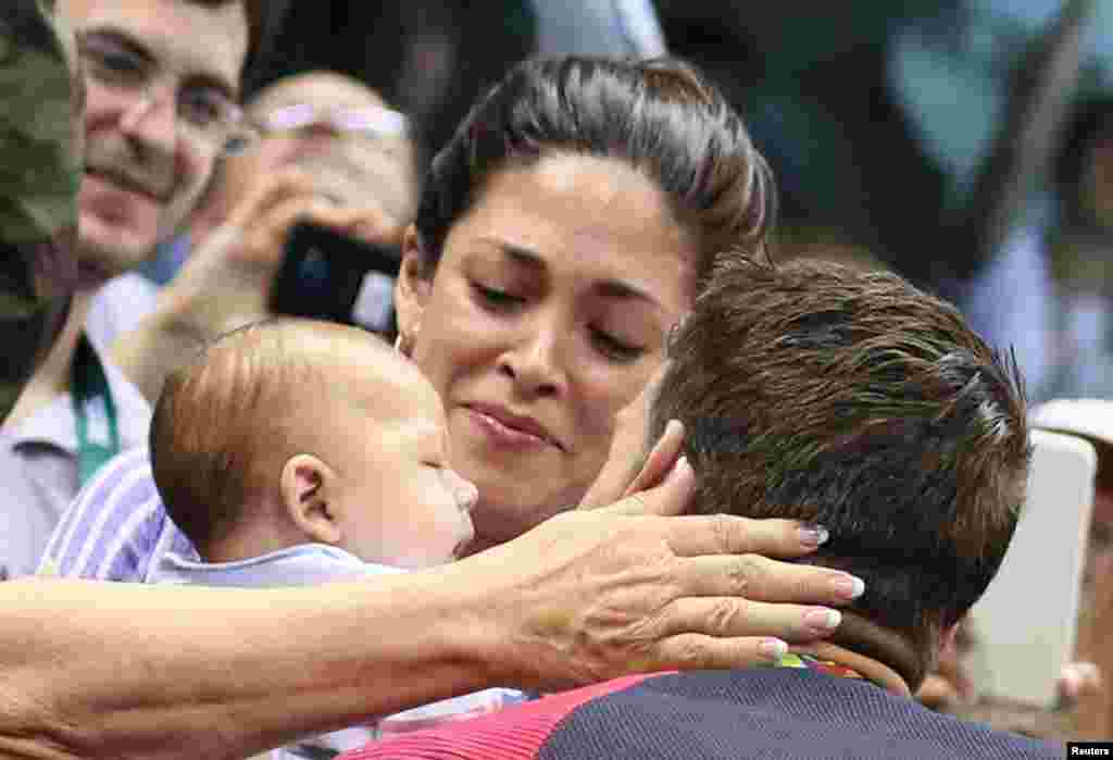 Michael Phelps embrasse sa fiancé Nicole Johnson et son bébé après sa victoire au 200 m papillon à Rio de Janeiro, Brésil, le 9 août 2016.