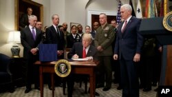 Después de firmar la Ley de Autorización de Defensa Nacional, el presidente Donald Trump saludó al secretario de Defensa, James Mattis y al vicepresidente Mike Pence, quienes lo acompañaron en el salón Roosvelt de la Casa Blanca.