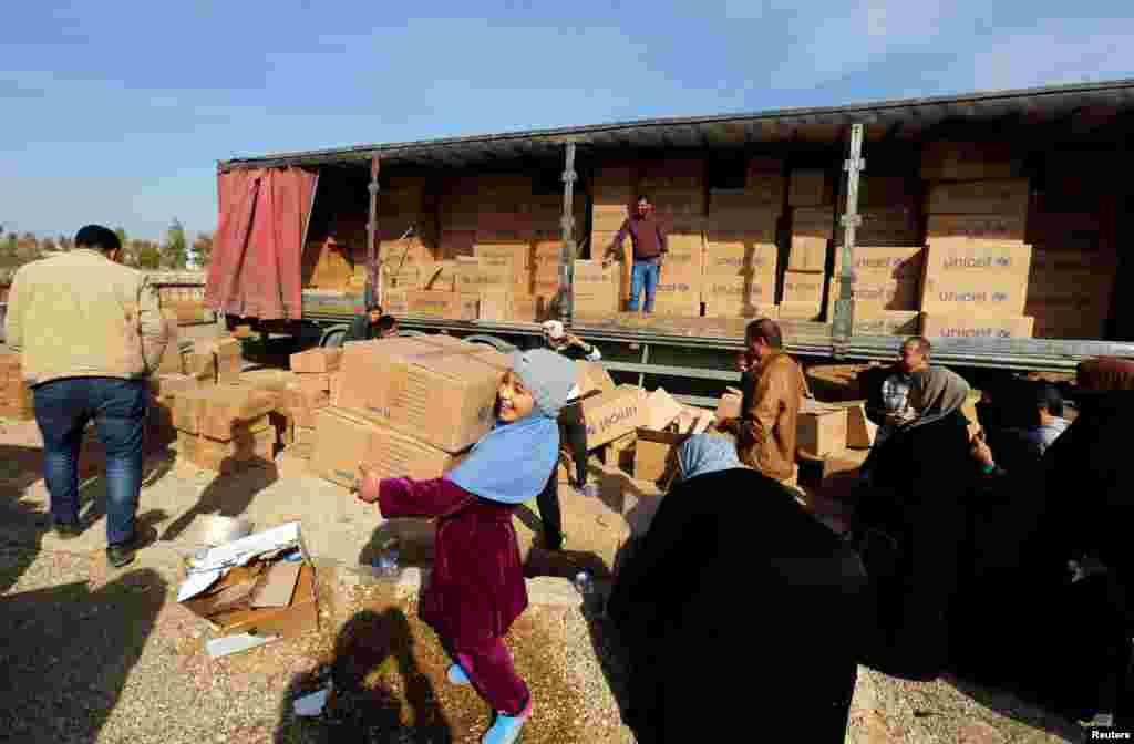 Displaced people who fled the clashes receive aid in northern Mosul, Iraq.