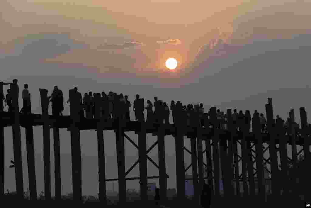អ្នកដំណើរ​ក្នុង​ស្រុក​និង​បរទេស​ដើរ​កាត់​​ព្រះ​អាទិត្យ​លិច​នៅ​លើ​ស្ពាន​ U Bein Bridge ស្ពាន​ឈើ​ដ៏​វែង​ជាង​គេ​ដែល​ភ្ជាប់​ច្រាំង​ពីរ​នៃ​បឹង Taungthaman ក្នុង​ទីក្រុង Mandalay ប្រទេស​មីយ៉ាន់ម៉ា​កាលពី​ថ្ងៃទី​០៣ មេសា ២០១៨។