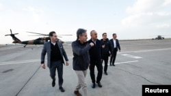 El Secretario de Estado de Estados Unidos, Antony Blinken, camina junto al ministro turco de Exteriores, Mevlut Cavusoglu, tras un viaje en helicoptéro por las zonas devastadas por el terremoto, cerca de Adana, Turquía, el 19 de febrero de 2023. 