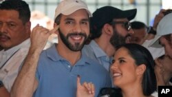 Presiden El Salvador Nayib Bukele, yang mencalonkan diri kembali, dan istrinya Gabriela Rodriguez menunjukkan jari mereka yang bertinta usai memberikan suara di San Salvador, Minggu (4/2). 