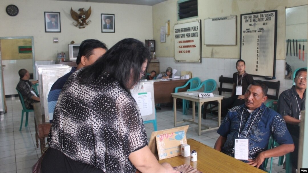 Warga di daerah Dolly menggunakan hak pilihnya. (VOA/Petrus Riski)