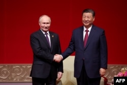 រូបឯកសារ៖ ប្រធានាធិបតីរុស្ស៊ីលោក Vladimir Putin និង​ប្រធានាធិបតី​ចិន​លោក Xi Jinping ចាប់ដៃគ្នា​ក្នុង​ជំនួបមួយ នៅរដ្ឋធានីប៉េកាំង ប្រទេស​ចិន កាលពីថ្ងៃទី១៦ ខែឧសភា ឆ្នាំ២០២៤។ (Alexander RYUMIN / POOL / AFP)