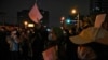 Protesters hold up blank papers and chant slogans as they gather on a street during a protest in Beijing, Nov. 27, 2022.
