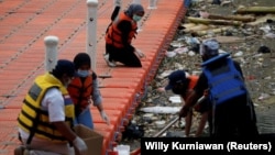 Anggota kelompok lingkungan Bank Sampah Sungai Cisadane (Banksa Suci) mengumpulkan sampah medis di Sungai Cisadane di Tangerang, Provinsi Banten, 2 Agustus 2020. (Foto: Reuters/Willy Kurniawan)