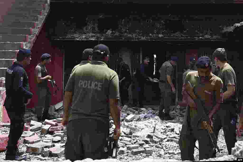 Police officials inspect a burnt Salvation Army church in Jaranwala on the outskirts of Faisalabad on August 17, 2023, a day after an attack by Muslim men following spread allegations that Christians had desecrated the Koran.