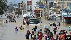 Residents wade through the floodwaters as they evacuate to safer grounds following massive flooding in Calumpit township, Bulacan province, north of Manila, Philippines, September 30, 2011.