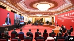 This general shot shows China's President Xi Jinping speaking with Russian President Vladimir Putin via a video link, from the Great Hall of the People in Beijing, Monday, Dec. 2, 2019. (Noel Celis/Pool Photo via AP)