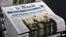 Copies of the French newspaper Le Monde with the headline "Trump Provokes Chaos in Washington" are seen at at Le Monde headquarters, in Paris, Jan. 7, 2021.