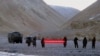 Pasukan China memegang spanduk bertuliskan: "Anda telah melintasi perbatasan, silakan kembali" di Ladakh, India. (Foto: AP)