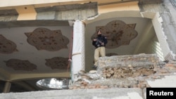 A police officer stands amid damaged structure, following a suicide blast in a mosque in Peshawar, Pakistan Feb. 1, 2023.