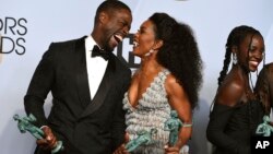 Sterling K. Brown, kiri, pemenang penghargaan untuk aktor terbaik dalam penampilannya di film “Black Panther” tampak bersama Angela Bassett yang juga tampil dalam film yang sama dalam acara penganugerahan tahunan Screen Actors Guild Award yang ke-25, hari Minggu, 27 Januari 2019,